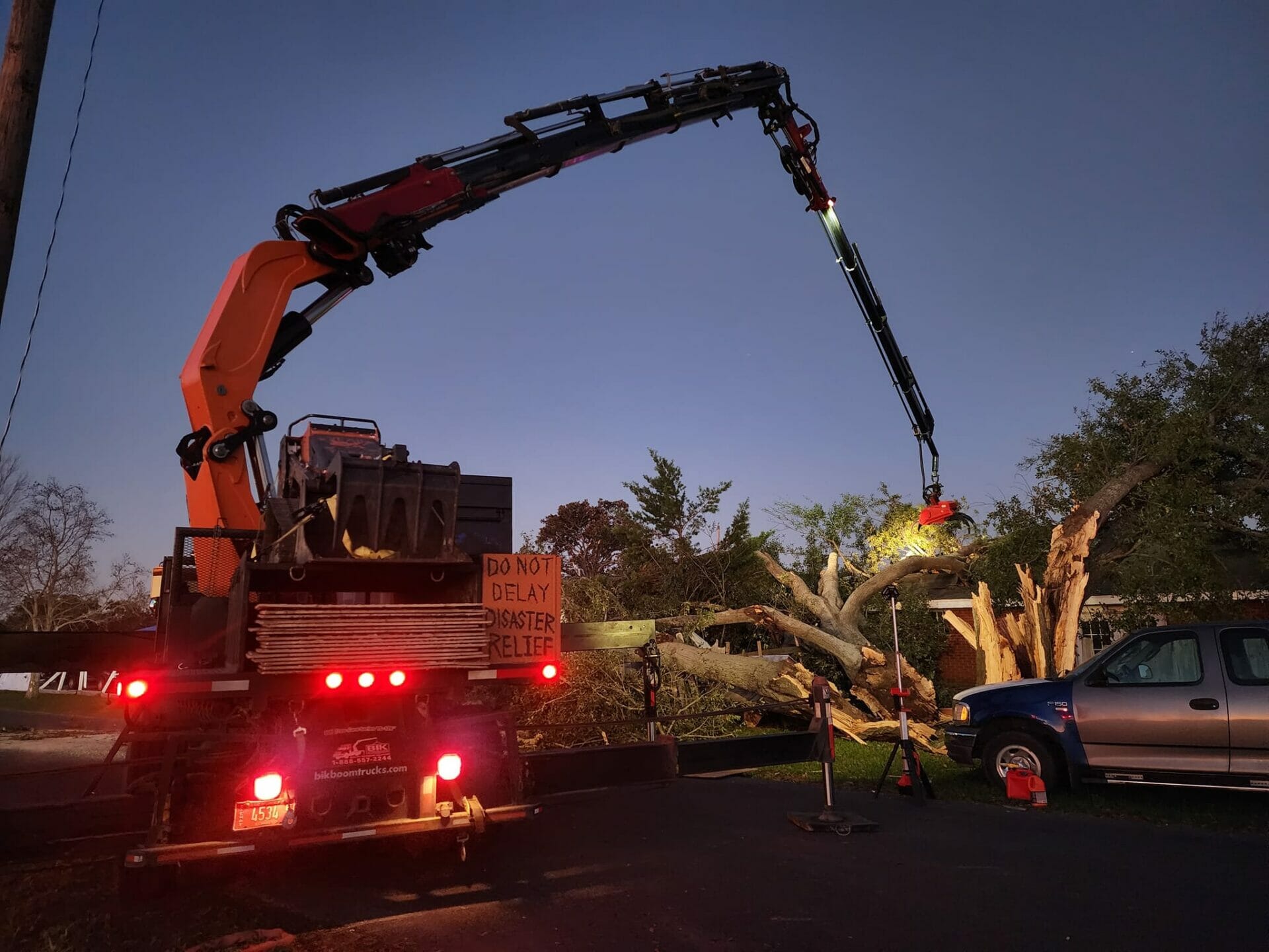 Crane truck used to help clean tree waste in yard